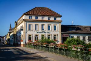 a white building with a red roof on a street at Hotel Waibstadter Hof in Waibstadt