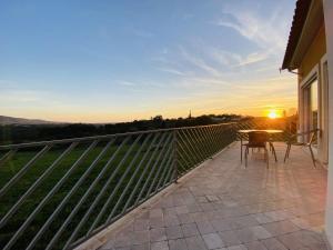 balcone con tavolo, sedie e vista sul tramonto di Casa De Campo Natureza a Porto de Mós Altre 11 foto