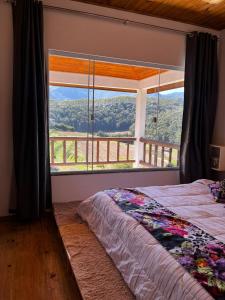 una cama en una habitación con una ventana grande en Pedra Azul - Casa Goiabeira II, en Domingos Martins 17 fotos más