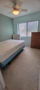 a bedroom with a bed and a ceiling fan at Cat & Coffee Prime City Access - Room 1 in San Diego