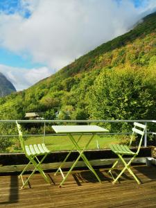 a picnic table and two chairs on a deck at La Colonie d'Antan in Collonges