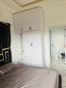 a bedroom with a bed and a bathroom with a toilet at Pebview 2 Bed Apartment in Kpone