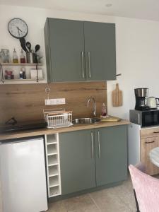 a kitchen with white cabinets and a sink at Les gîtes de la Baie la hutte in Favières