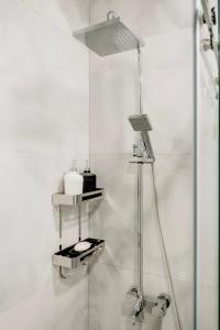 a white bathroom with a shower with a lamp at Nest One Luxe, Элитные апартаменты с балконом и видом на фонтан Tashkent City Park 077 in Tashkent