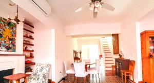 ein Wohnzimmer mit Tisch und Stühlen und einem Deckenventilator in der Unterkunft La Casa Rosada del Barrio Histórico in Colonia del Sacramento + 36 Fotos