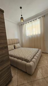 a large bed in a room with a window at Jad Appartement N1 in Essaouira +3 photos