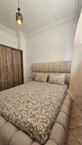 a bedroom with a bed with a large headboard at Jad Appartement N1 in Essaouira