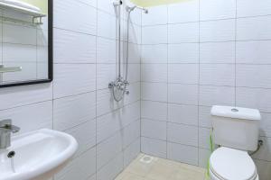 a bathroom with a shower and a toilet and a sink at Equinox Vacation Apartments in Bulambiro