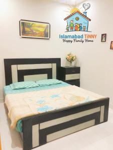 a bedroom with a bed with a sign on the wall at Islamabad Tinny Happy Family Home in Islamabad
