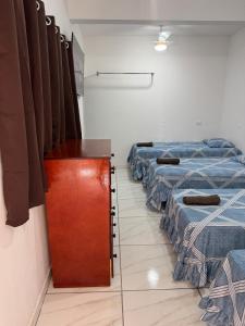 a room with three beds and a wooden door at Cozy house near Vila Aurora Station in Sao Paulo