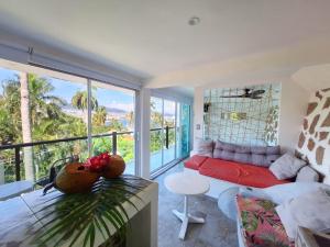a living room with a red couch and a large window at Casa Breizh in Acapulco
