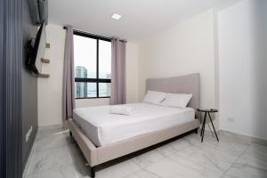 a bedroom with a white bed and a window at 1BR Amazing sea view in Calle 50 in Panama City