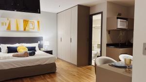 a bedroom with a bed and a table and a kitchen at Flat na Barra da Tijuca in Rio de Janeiro +33 photos