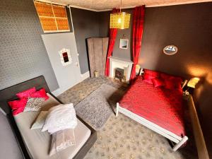 an overhead view of a bedroom with a bed with red pillows at Chambre Anthracite in Chénérailles