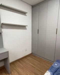 a bedroom with white walls and a wooden floor at Quartoo Individual in Belo Horizonte