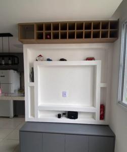a white shelf in the corner of a kitchen at Quartoo Individual in Belo Horizonte