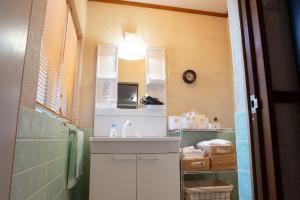 a bathroom with a sink and a mirror at 中通りハウス in Zentsuji +26 photos