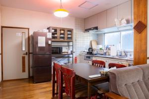 a kitchen with a table and a refrigerator at 中通りハウス in Zentsuji