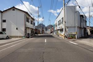 an empty street in a town with buildings at 中通りハウス in Zentsuji