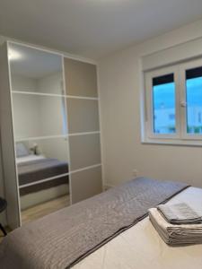 a bedroom with a bed with a mirror and a tub at Meštralun in Zadar