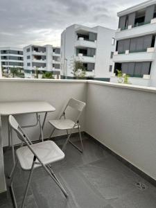 two chairs and a table on a balcony with buildings at Meštralun in Zadar