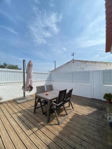 a wooden deck with a table and chairs on a roof at Sunny Aljezur da Viana, (Aljezur, Costa Vicentina) in Aljezur