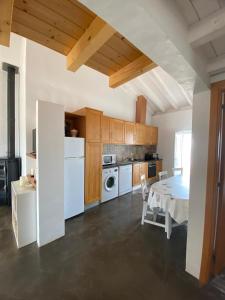 a kitchen with a table and a white refrigerator at Sunny Aljezur da Viana, (Aljezur, Costa Vicentina) in Aljezur
