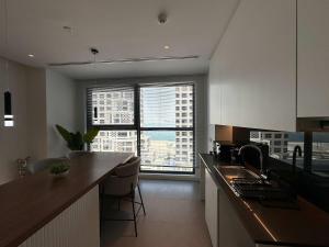 a kitchen with a counter and a large window at Stylish Waterfront 1BR on Al Reem Island in Mushayrib