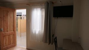 a room with a window with a television and a door at Nueva Carrera in Illapel
