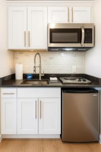 a kitchen with white cabinets and a sink and a microwave at Perfect Downtown Stay Yale Walk Sallys Apizza in New Haven