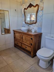 une salle de bain avec un lavabo, des toilettes et un miroir dans l'établissement Sítio São João, à Córrego do Bom Jesus