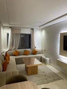 a living room with a couch and a tv at Mansouria Luxury Escape in Mohammedia