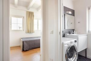 bagno con lavatrice in camera di WAVE'S GLASS Industrial loft in old Murano a Venezia