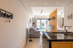 een keuken en een woonkamer met een bureau en een bank bij Apartamento top 40m2 Trend 24 Moinhos de Vento in Porto Alegre