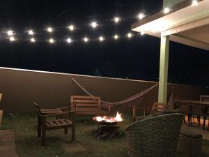 een vuurplaats in een achtertuin 's nachts met lichten bij Refugio 4 suites com ar condicionado e piscina in Águas de Santa Barbara