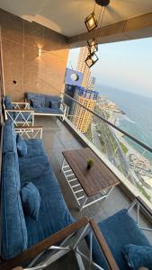 a balcony with couches and a table and the ocean at شقة ثلاث غرف مطلة على البحر في برج داماك جدة in Jeddah