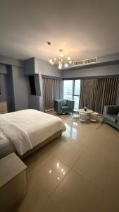 a bedroom with a large bed and a living room at شقة ثلاث غرف مطلة على البحر في برج داماك جدة in Jeddah