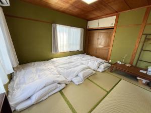 a large bed in the corner of a room at 中通りハウス in Zentsuji