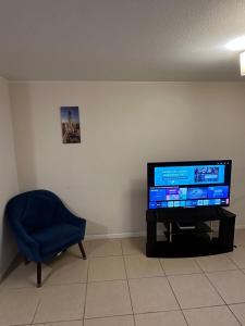 a living room with a tv and a blue chair at Serena Centro & Playa Apartment in La Serena