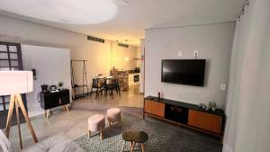 a living room with a flat screen tv on a wall at Studio do Bosque em Ponta Porã in Ponta Porã