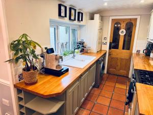 a kitchen with a counter with a sink and a window at Lilac Cottage in Farington