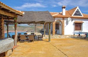 a patio with a table and chairs next to a house at La Villa del Lago in Iznájar