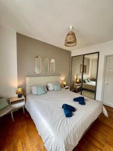 a bedroom with a large white bed with mirrors at Appartement élégant Championnet - 3 chambres - parking privé in Grenoble
