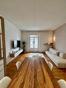 a living room with a wooden table and a couch at Appartement élégant Championnet - 3 chambres - parking privé in Grenoble