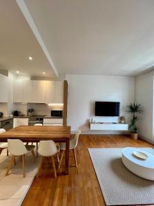 a kitchen and dining room with a table and chairs at Appartement élégant Championnet - 3 chambres - parking privé in Grenoble