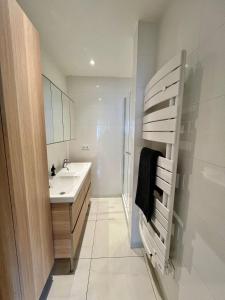 a bathroom with a sink and a towel ladder at Appartement élégant Championnet - 3 chambres - parking privé in Grenoble