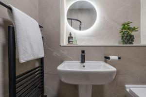 a white sink in a bathroom with a mirror at Sunnie stays apartment harrington chambers in Liverpool +18 photos