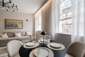 a living room with a table and chairs and a couch at Sunnie stays apartment harrington chambers in Liverpool