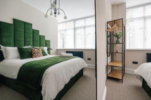 a bedroom with a large bed with a green headboard at Sunnie stays apartment harrington chambers in Liverpool