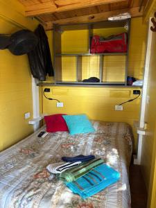 a bed in a small room with towels on it at Tiny House con parrilla y jardín cerca del mar in Colonia Chapadmalal